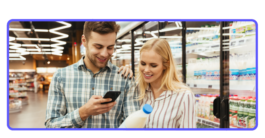¿Comida muy cara? Ahorra con cupones y cashback en esta app 3 Pareja en supermercado leyendo lista de compras con la app Ibotta
