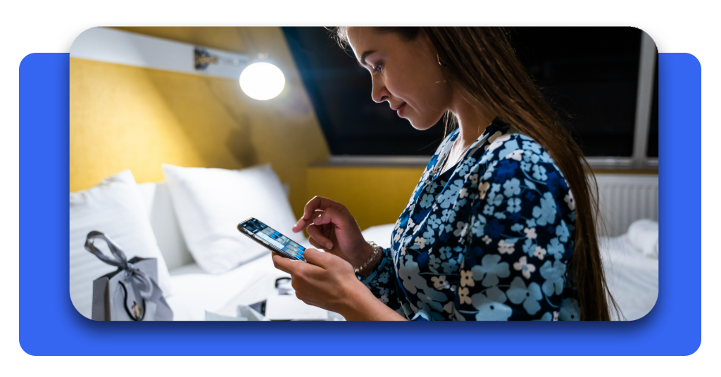 Mujer joven consultando en su teléfono inteligente la aplicación para monitorear el consumo de luz y ahorrar en la factura eléctrica del hogar.